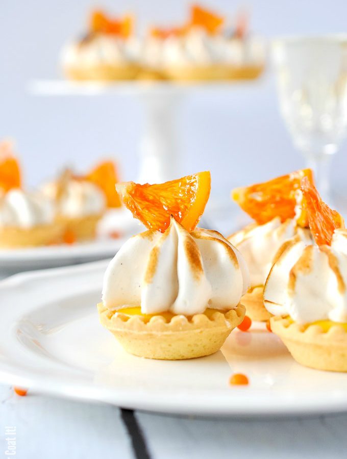 Candied Cara Cara Curd Meringue Tarts are mini bites of sweet, tangy, creamy sunshine topped with clouds of vanilla bean meringue and candied oranges.