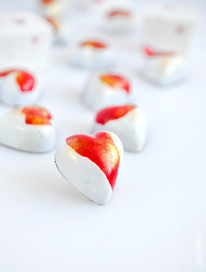 Heart bonbons decorated with splashes of red and gold on white | i sugar coat it