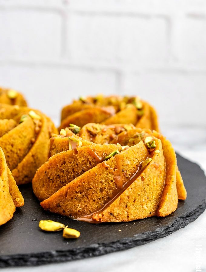 Flavour-packed, melt-in-your-mouth Pistachio Orange Caramel Mini Bundt Cakes, drizzled with orange caramel and topped with candied pistachio.