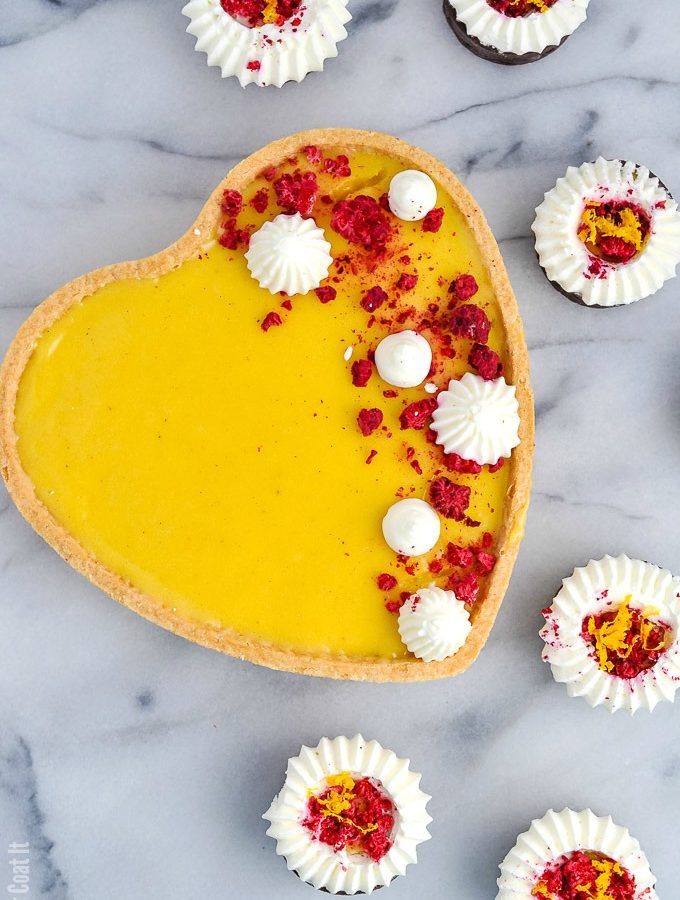Luscious Yuzu White Chocolate Tart is flavourful, fragrant yuzu lemon and silky white chocolate piped into sweet pastry and topped with freeze-dried raspberry and whipped cream.