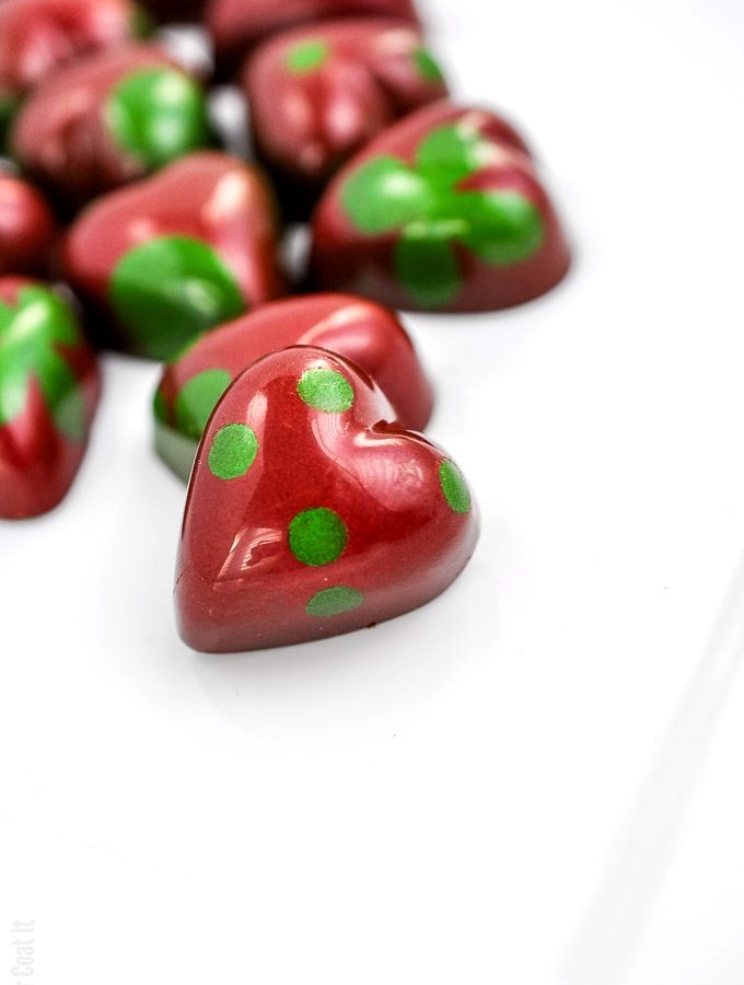 heart-shaped bonbon painted in shiny red with green polka dots | i sugar coat it