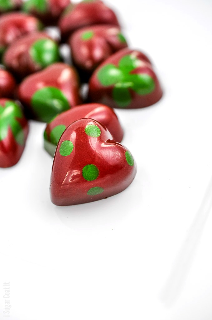 heart-shaped bonbon painted in shiny red with green polka dots | i sugar coat it