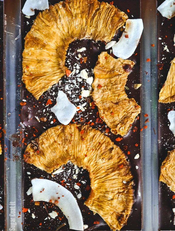 Spicy Pina Colada Dark Chocolate Bar with coconut rum-soaked dehydrated and freeze-dried pineapple, shaved coconut and Aleppo flakes on dark chocolate.