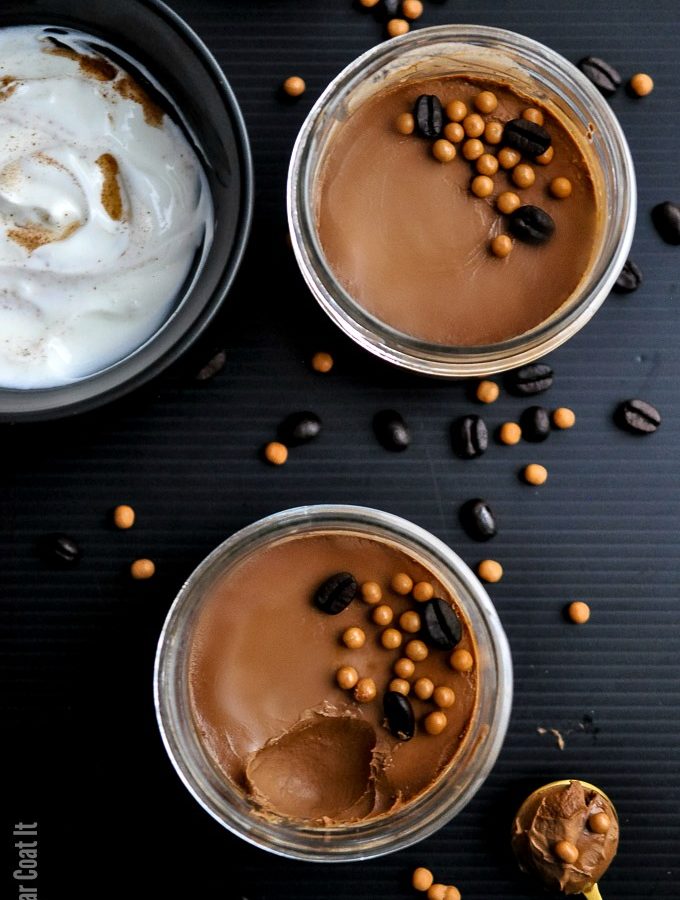 sous vide chocolate coffee pots de creme with chocolate coffee beans and crunch pearls on a black background. | i sugar coat it