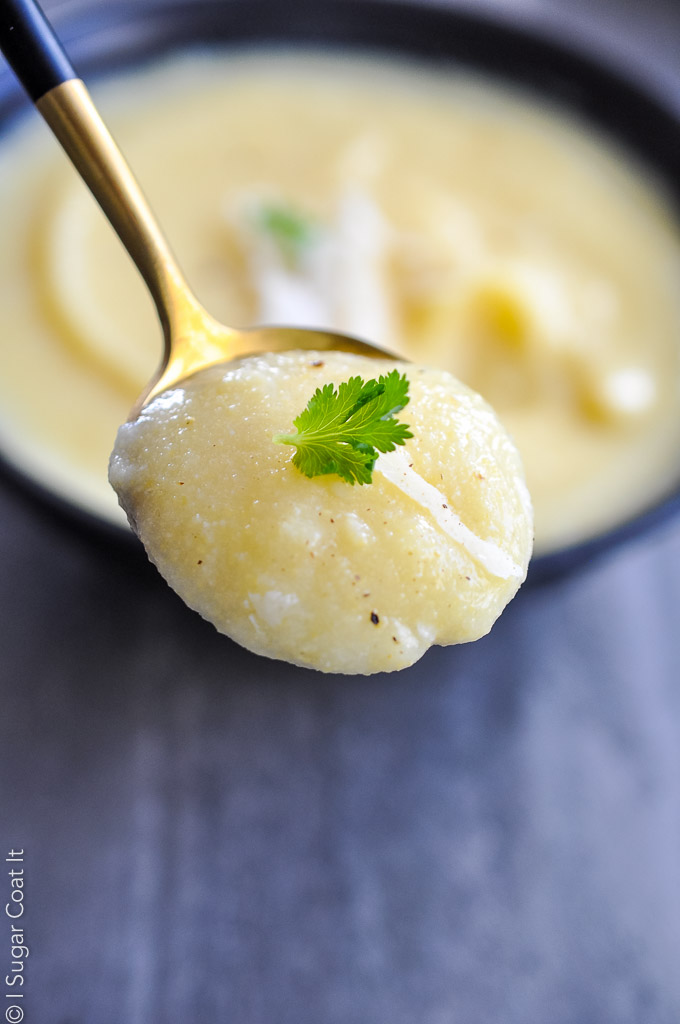 gold spoon with a scoop of polenta, with bowl in background | i sugar coat it