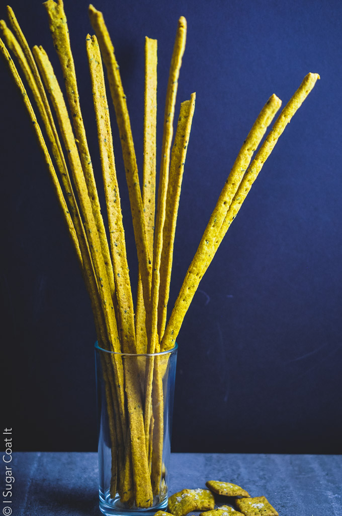 bright yellow cracker sticks arranged in a glass container against black backdrop | i sugar coat it